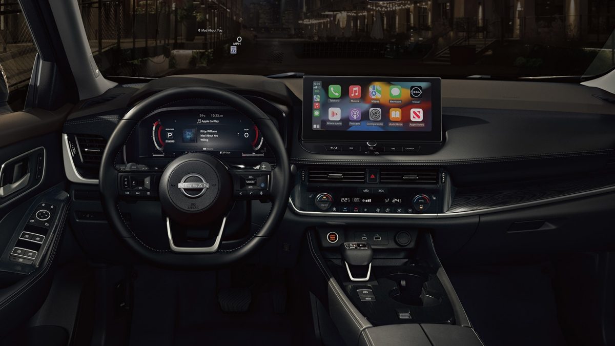 Detalle interior frontal de Nissan X-Trail 2025 con palanca de cambios e interiores premium.