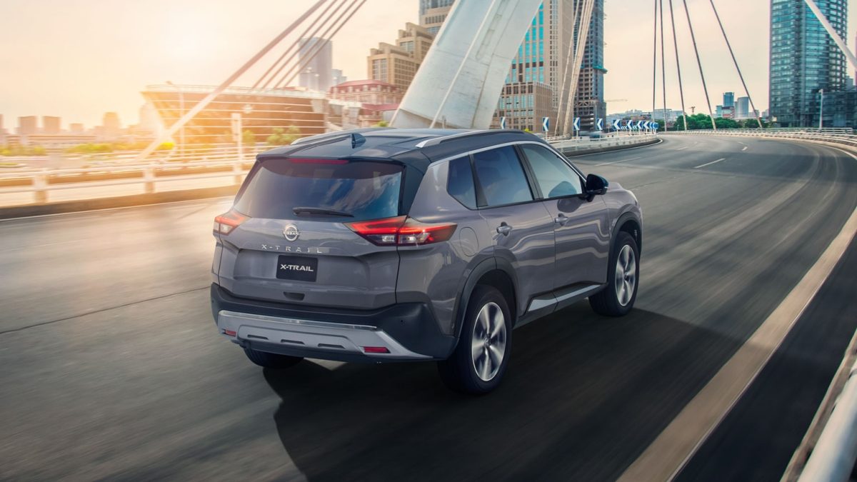SUV X-Trail color gris en carretera al atardecer